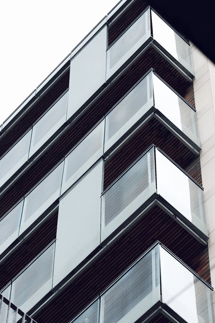 why-choose-us-02 Low angle view of a modern glass building facade in Jönköping, Sweden.